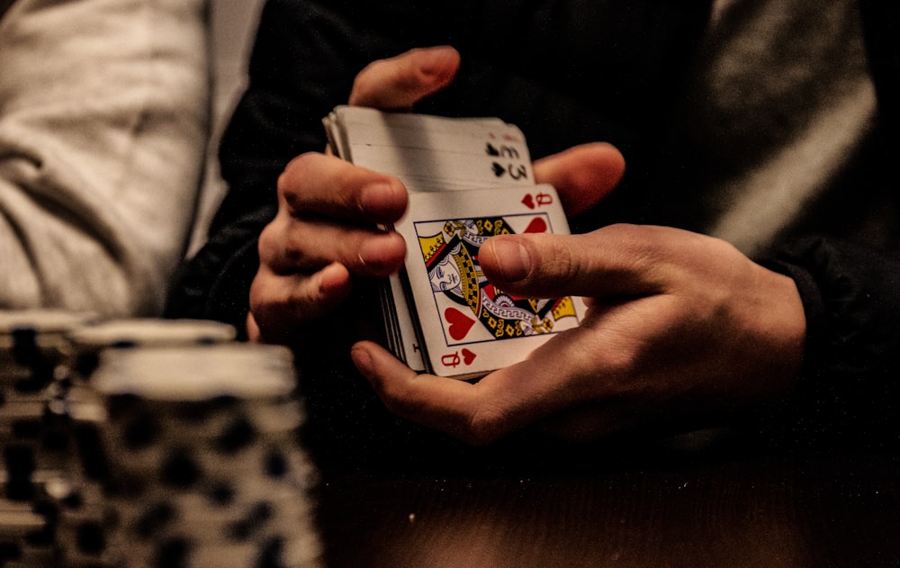 Tangan memegang kartu king saat bermain poker